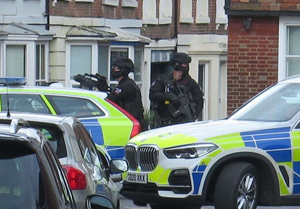 Armed police in Monastery Street, Canterbury, train their weapons on a building