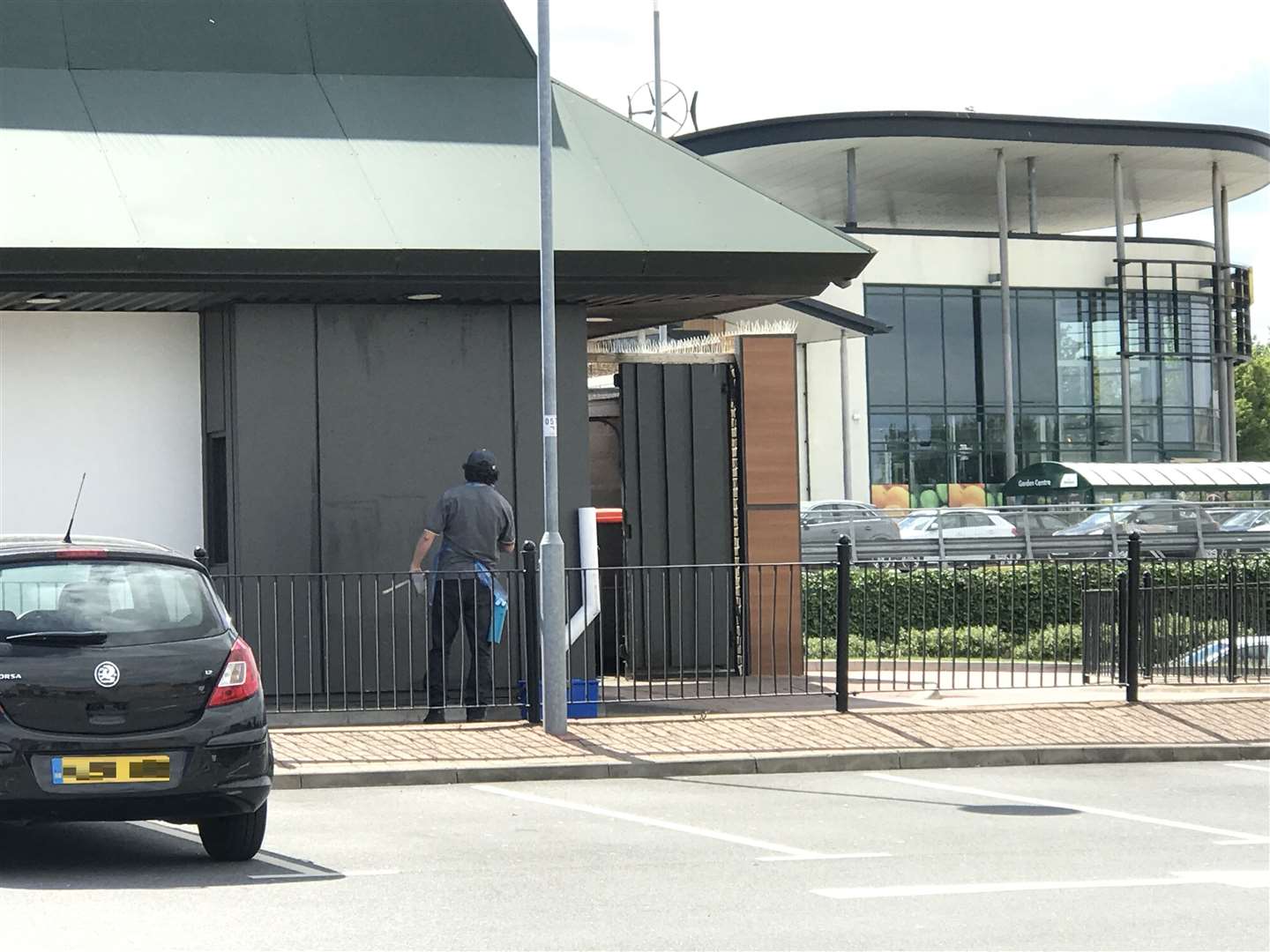 A worker cleaning the outside of McDonald's at the Sittingbourne Retail Park ahead of it's re-opening