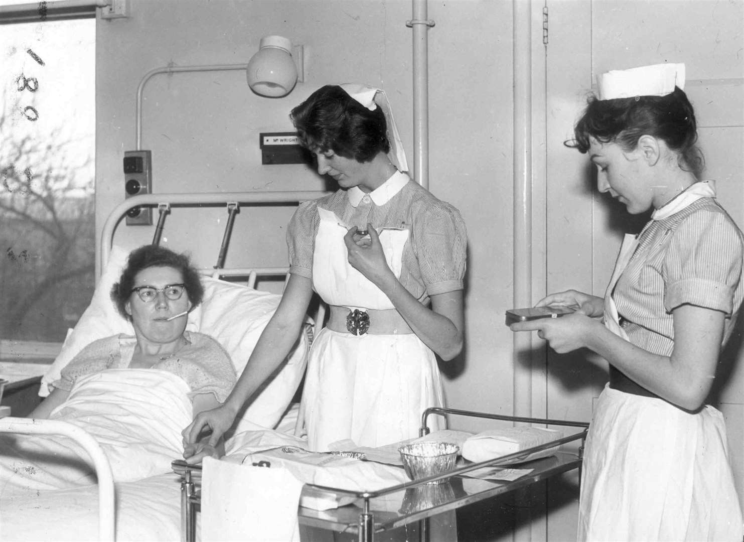 Nurses looking after a patient in ''Miriam'' Women's surgical ward at All Saints Hospital, Chatham, in January 1962
