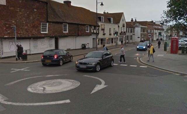 A Google Street View image showing pedestrians dodging past moving traffic