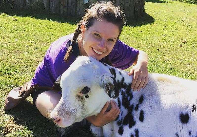 A volunteer hugs a calf at the sanctuary for rescued animals