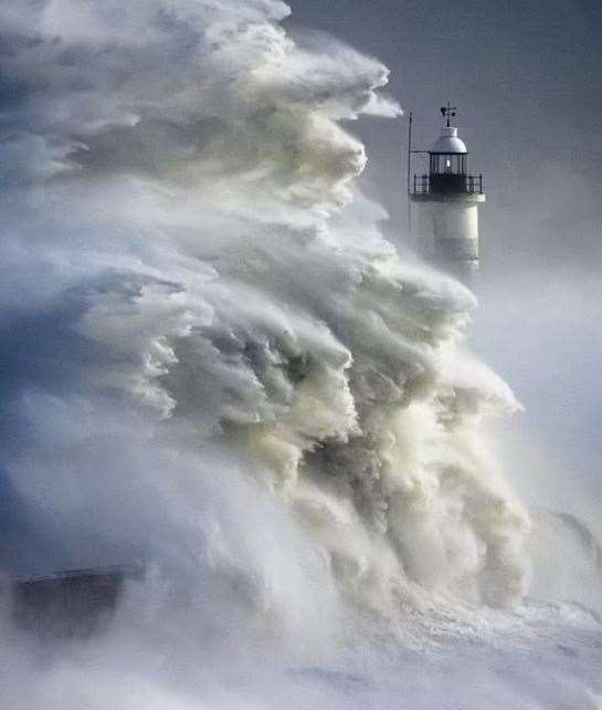 Huge waves smashing against a lighthouse in West Sussex during Storm Eunice were pictured by Christopher Ison