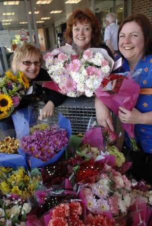 Yvonne Archer, from the Pilgrims Hospice, centre, with the flowers donated by Sainsbury's and Gillian Turner and Jane Sarrat from the store