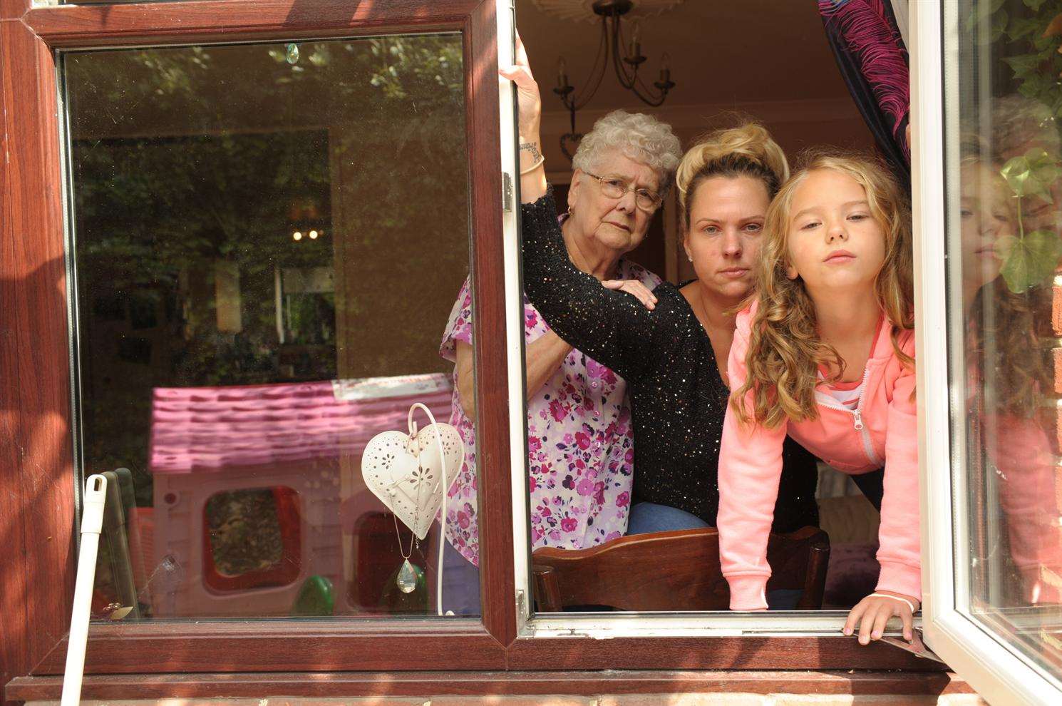 Shari Cairns, Faith Gore and grandma Dorothy Baston by the window they have to climb through to get to the garden