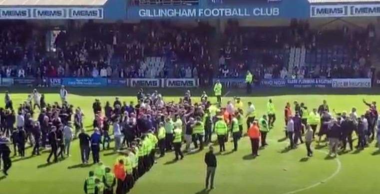 Rival fans meet in the middle of the Priestfield pitch at the end of Gillingham versus Rotherham game on April 30