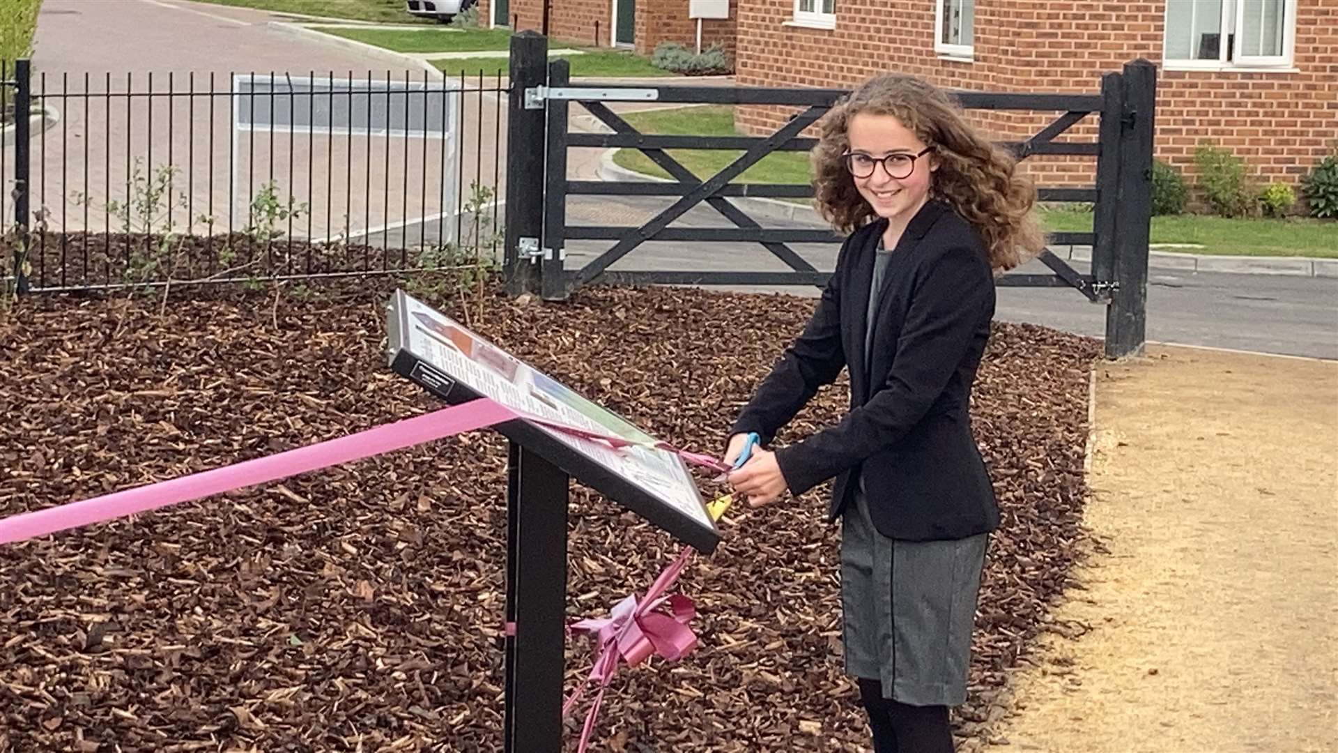 Ellie Wolfe, 12, cuts the ribbon to unveil the Romano-British temple uncovered outside her home in Newington near Sittingbourne. She attends Rainham Mark Grammar School