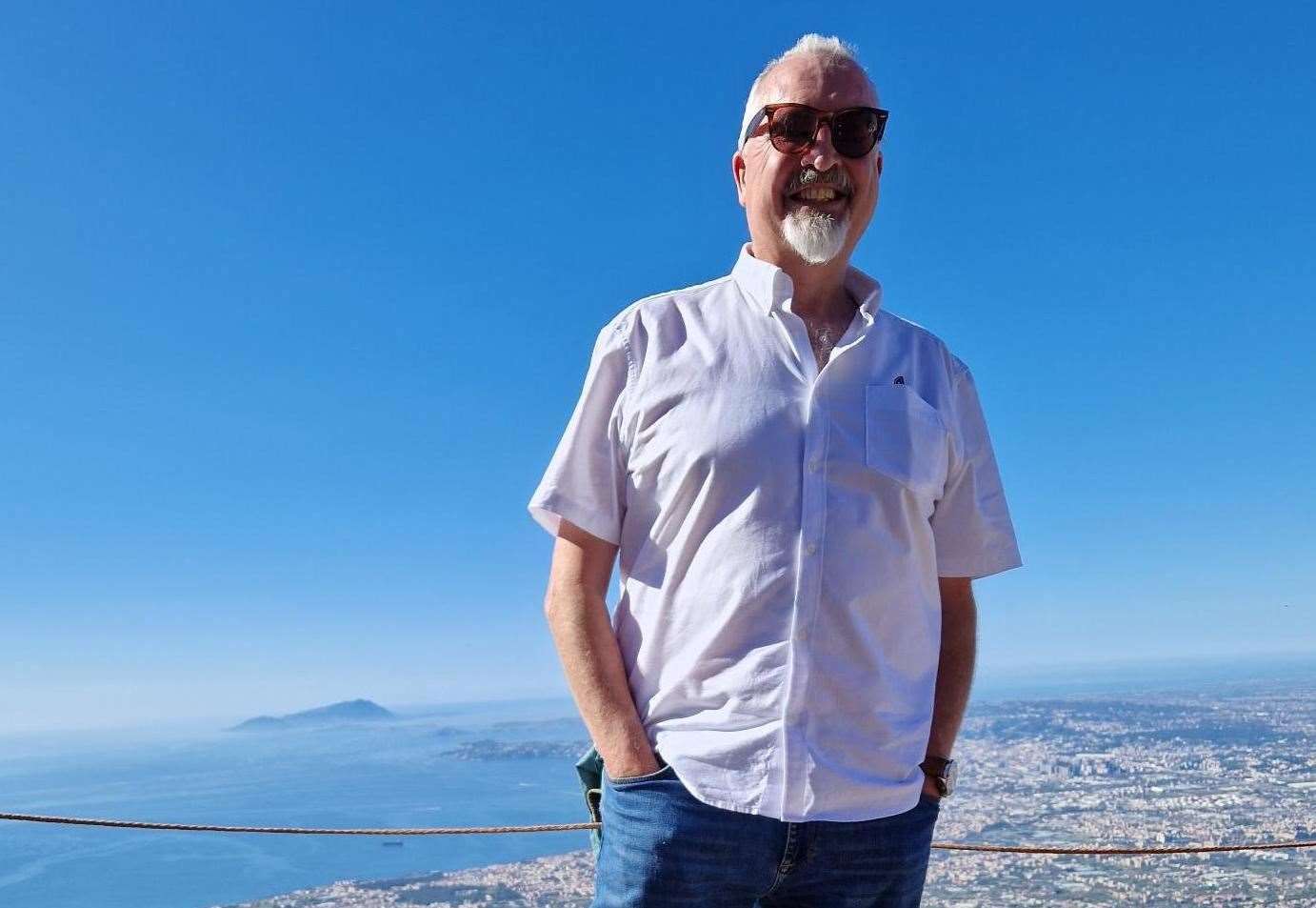 Dr Simon Elliott stood on top of Versuvius - on the crater his grandfather saw being created - with Naples in the background