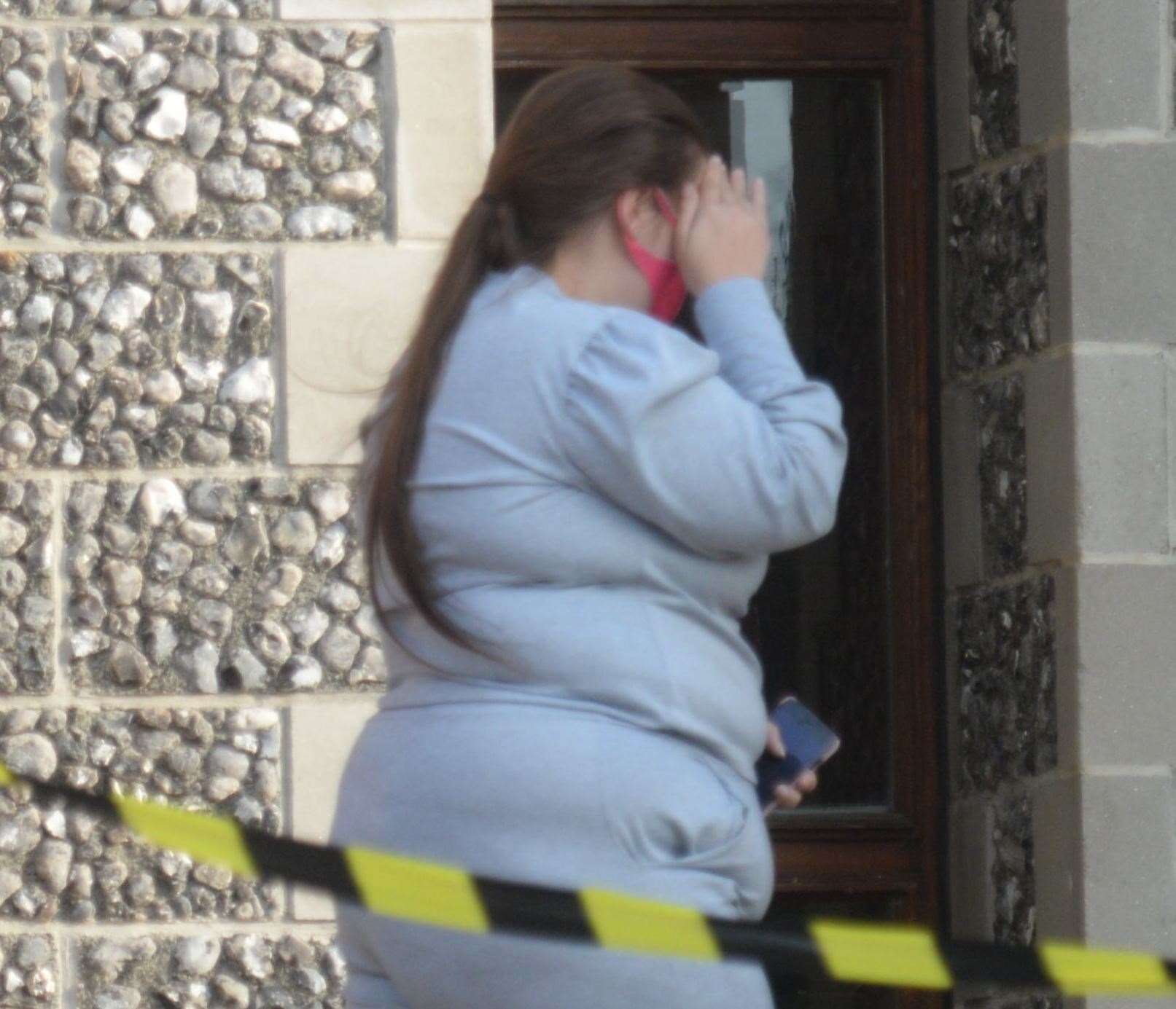 Naomi Roberts hides her face as she leaves Canterbury Crown Court