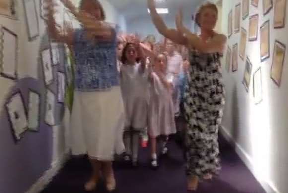 The staff and pupils are filmed dancing around the school