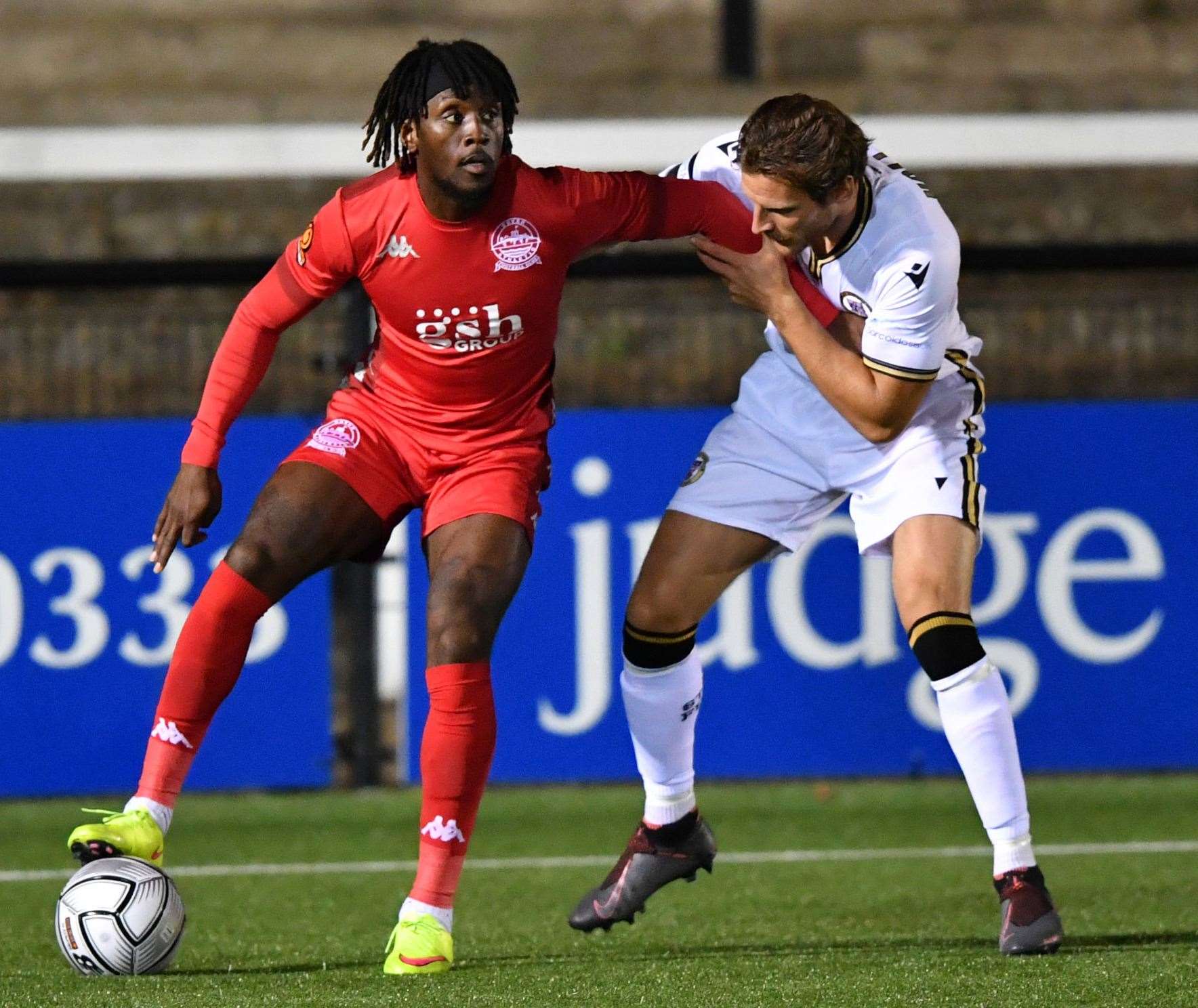 Dover's Ade Azeez holds the ball up under pressure from Bromley's Jack Holland. Picture: Keith Gillard