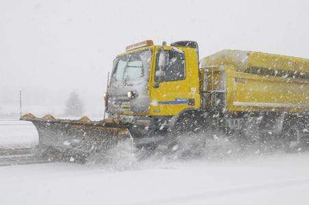 A snow plough makes its way through the winter weather