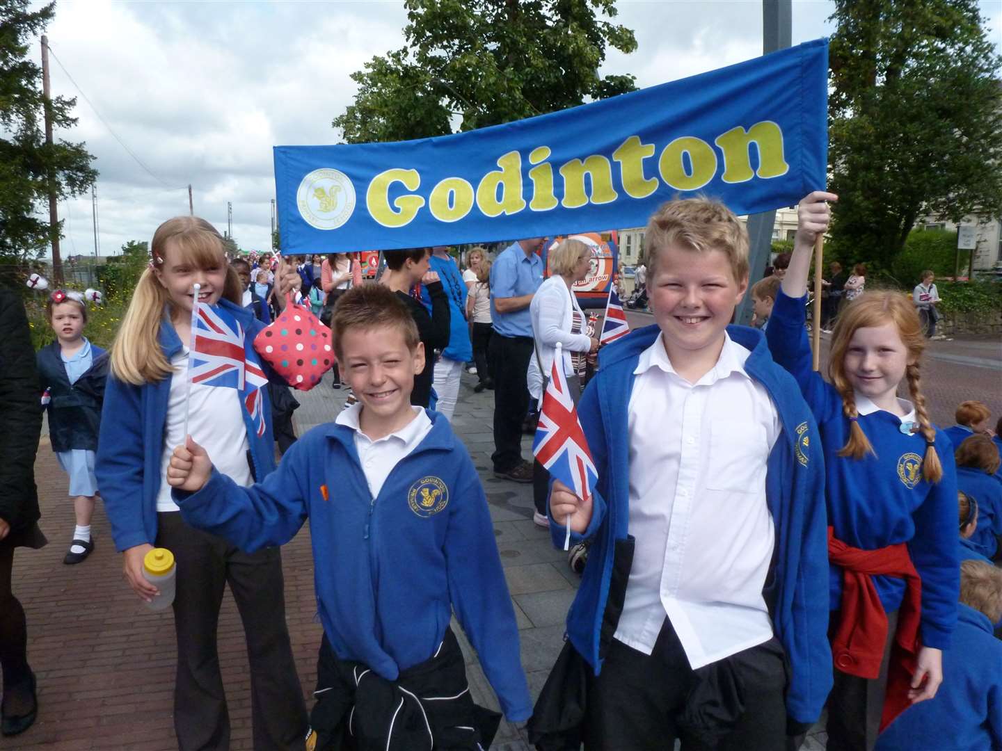 Children from Godinton Park Primary School waiting for the torch in Elwick Road, Ashford