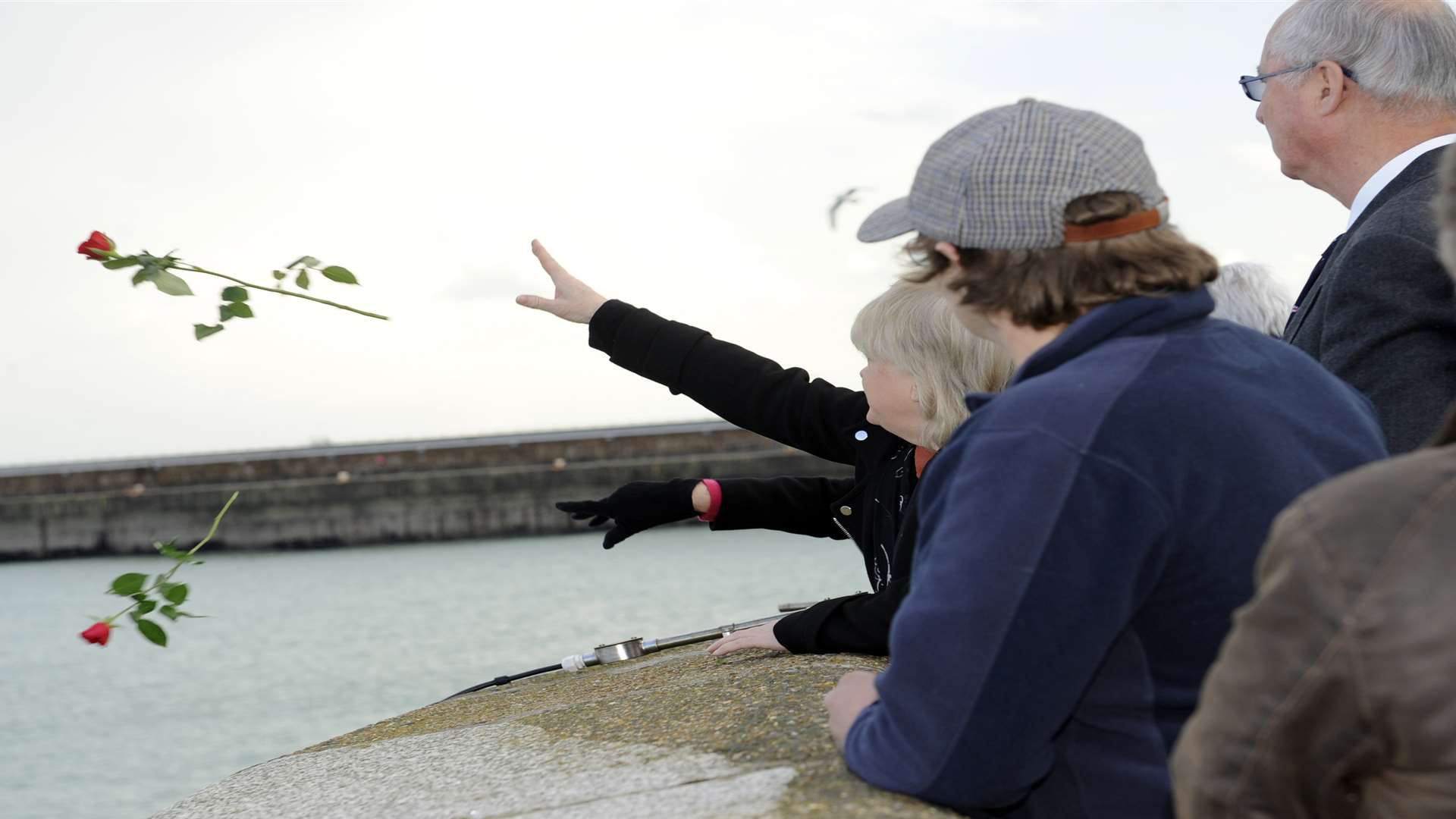People throw flowers into the sea in Dover during a memorial service last year