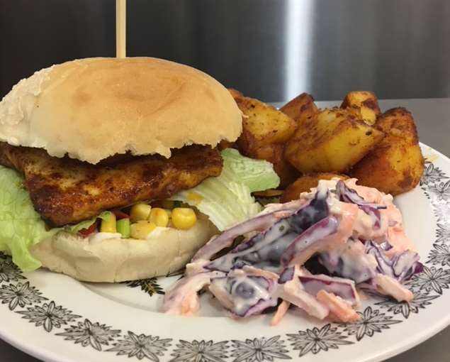 Pedi pedi halloumi burger with spicy corn salsa, lime mayo and served with garlic paprika potatoes and housemade coleslaw