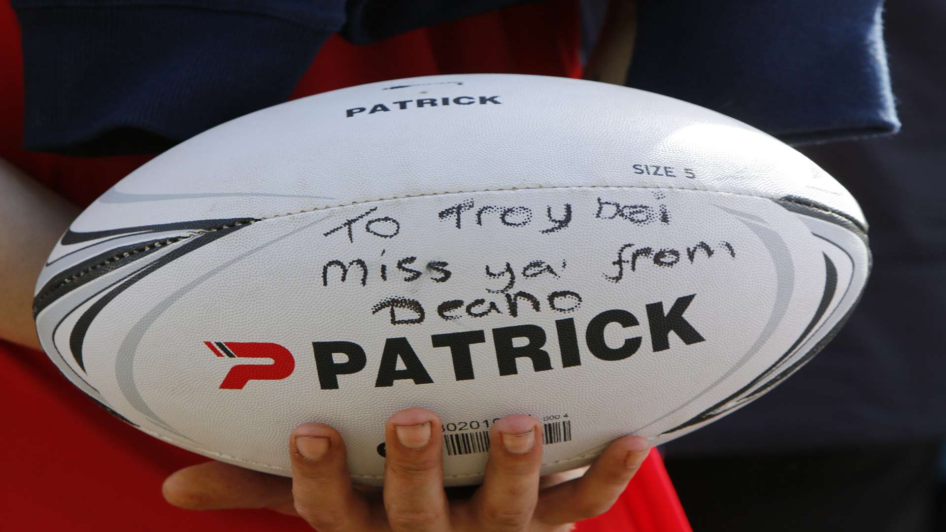 A friend leaves a tribute to Troy on a rugby ball