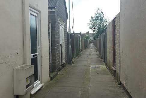 The suspect was led out of this alleyway in handcuffs