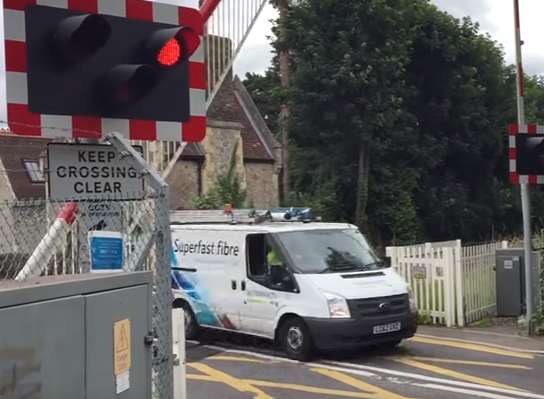 The van speeds up to get through the level crossing