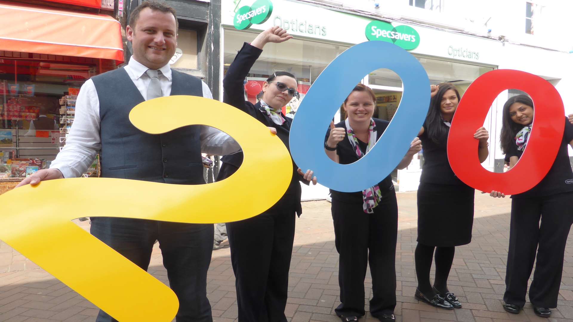Specsavers Kent Chairman Matt Trusty and staff at Specsavers Deal celebrate KM Walk to School schemes removing 200,000 school run journeys from the county’s roads.