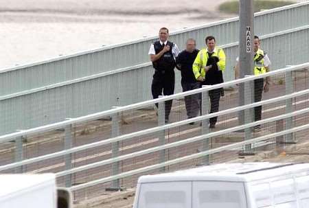 The man is escorted away by police officers. Picture: BARRY CRAYFORD