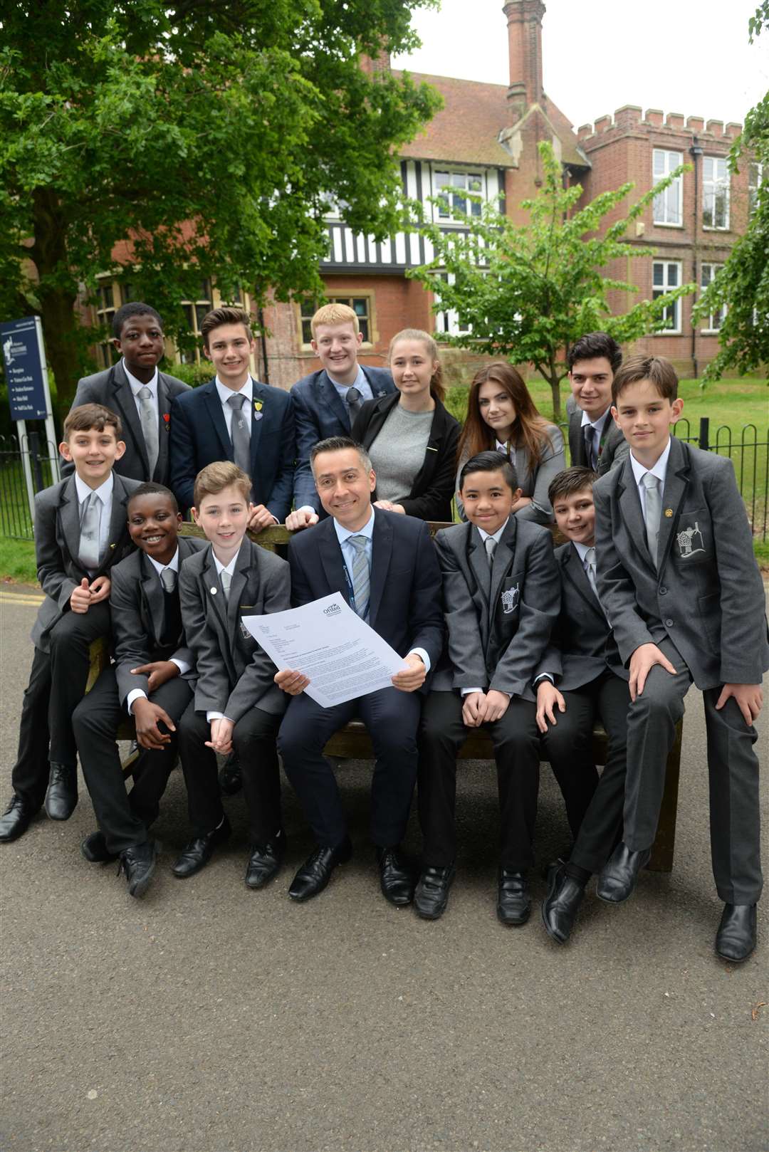 Executive Principal Gwynn Bassan and some of his pupils read through Holcombe Grammar Schools good Ofsted report. Picture: Chris Davey (2228443)