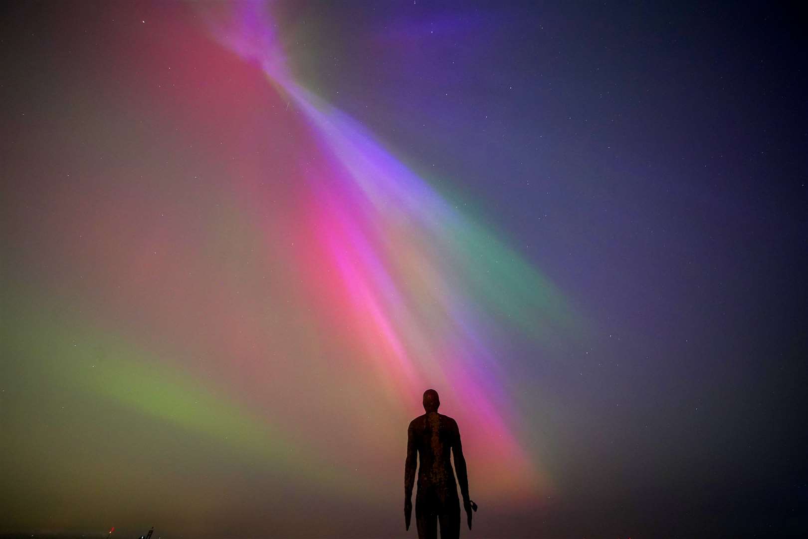 The aurora borealis glow on the horizon at Another Place by Anthony Gormley at Crosby Beach, Liverpool (Peter Byrne/PA)
