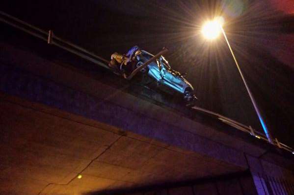 The car hangs over the M26 carriageway. Picture: @kentpoliceroads