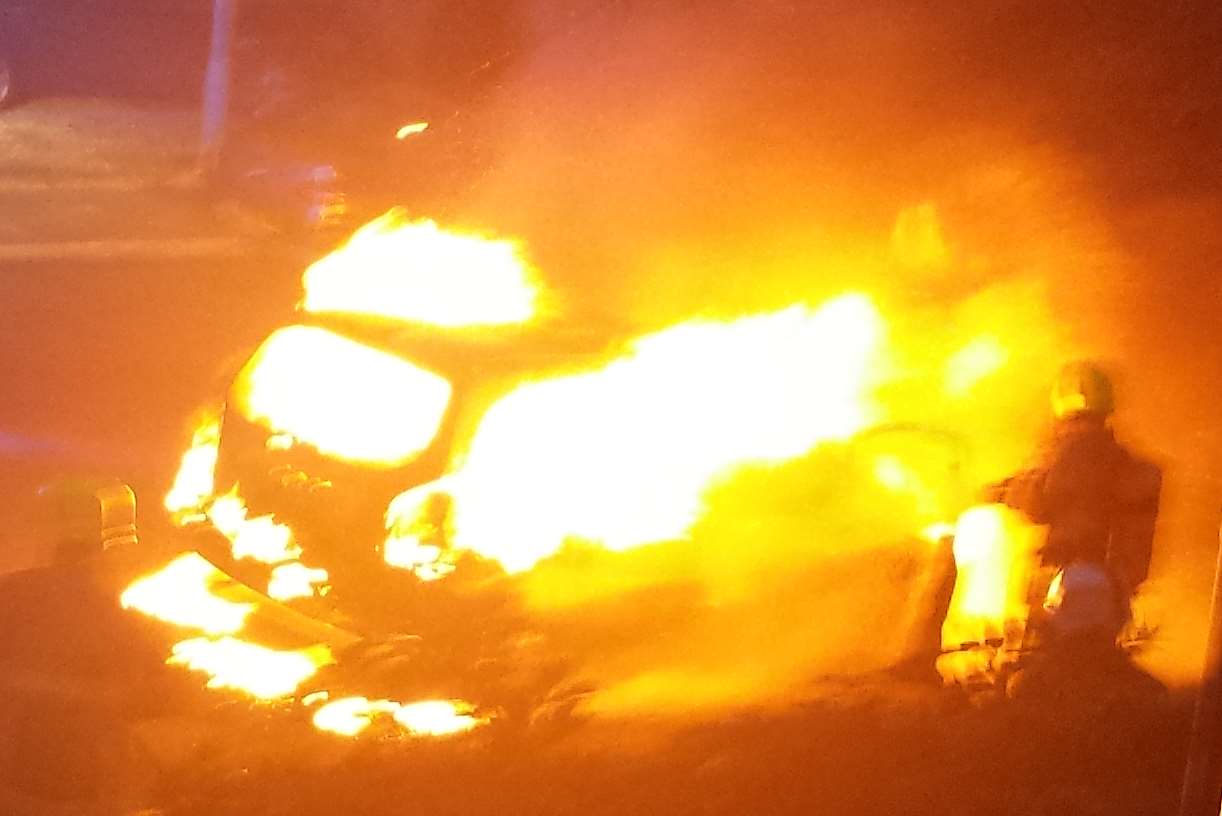 A firefighter tackles a blazing car in Faversham. Picture: Richard Brittain