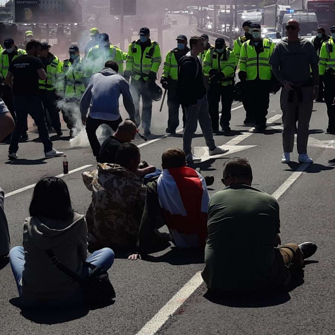Protesters today sat on the road at Snargate Street as officers approached to move them. Picture: Sam Lennon