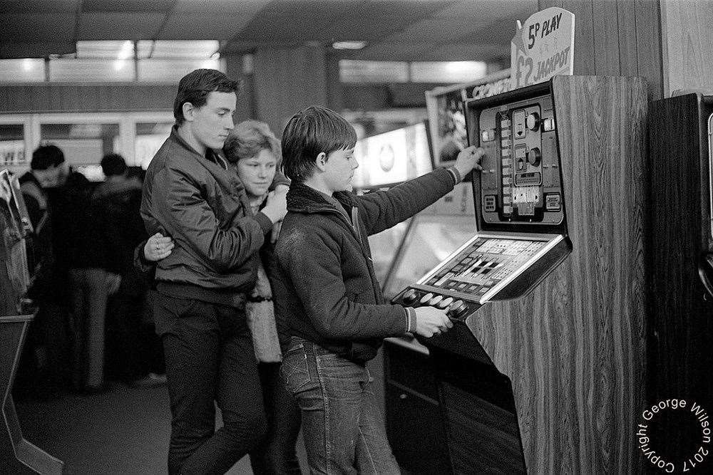 Two lovebirds look on as this boy tries to win the £2 jackpot. Copyright: George Wilson