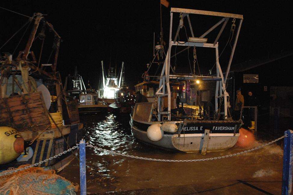 Fishing vessels strain at their moorings as the tide rises in Whitstable harbour