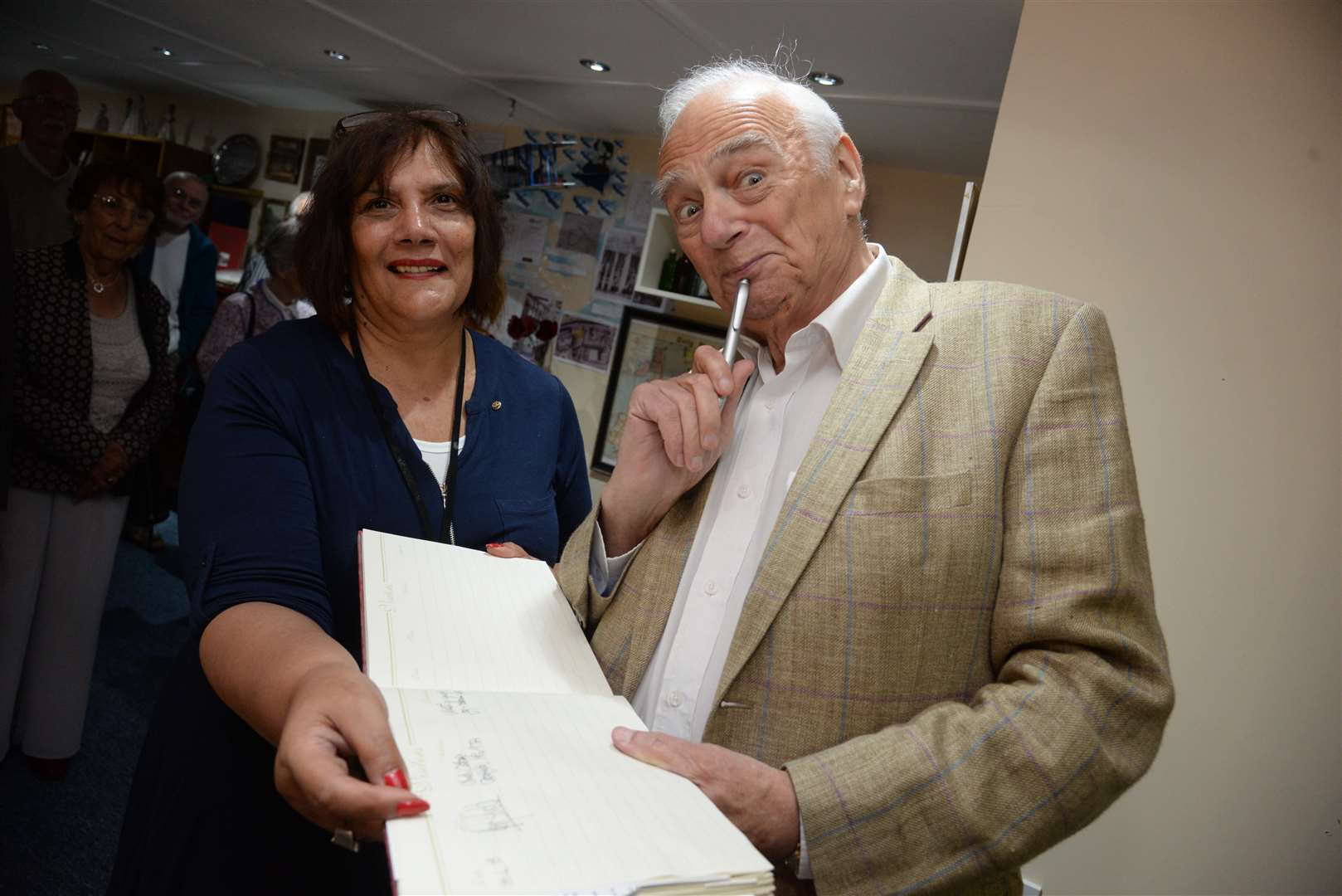 Jenny Hurkett watches as veteran comic Roy Hudd signs the visitors book after opening the new floor and display at the Blue Town Heritage Centre, Sheerness. Picture: Chris Davey