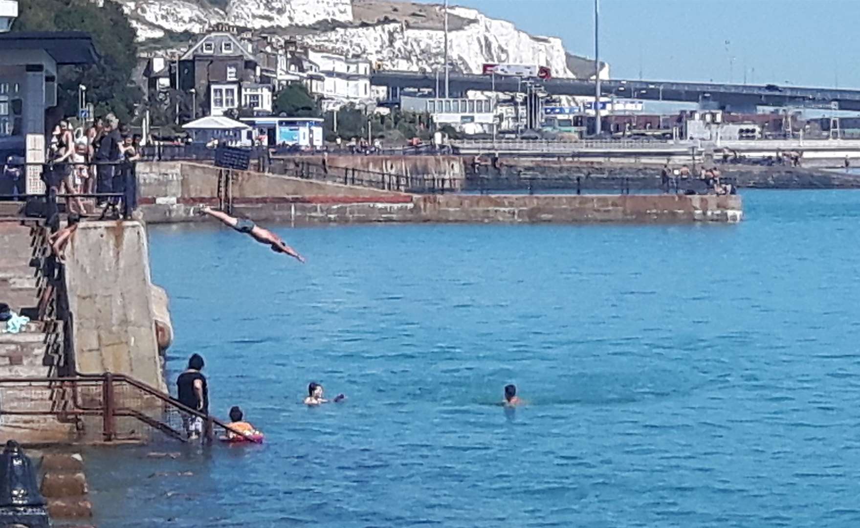 People jumping into the water at Dover Harbour