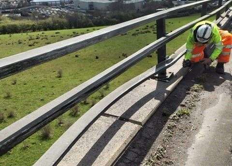 A workman with the damaged barrier at the Roundhill Tunnel site. Picture: National Highways