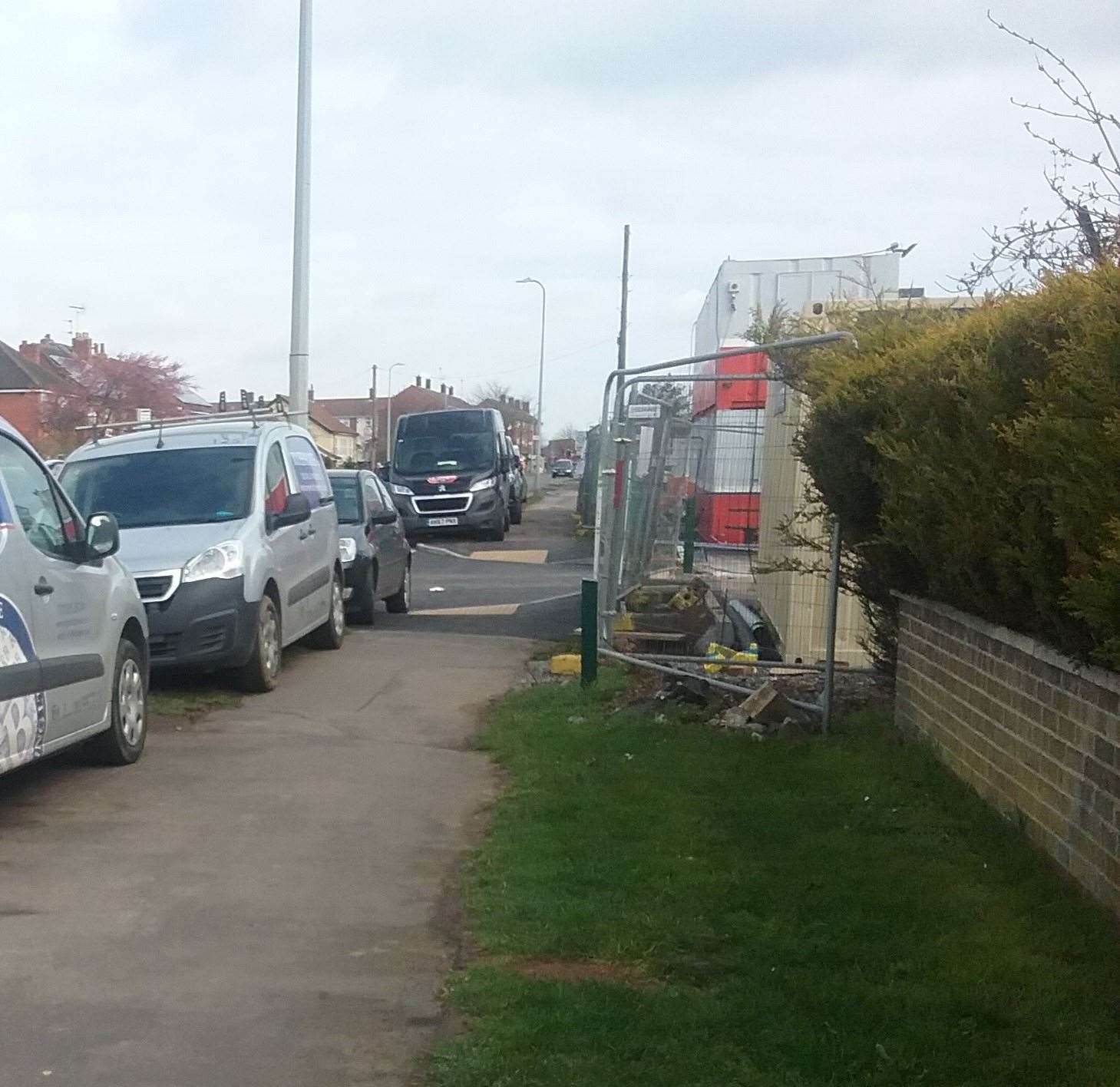 Cars and vans parked on New Beacon Road pavement