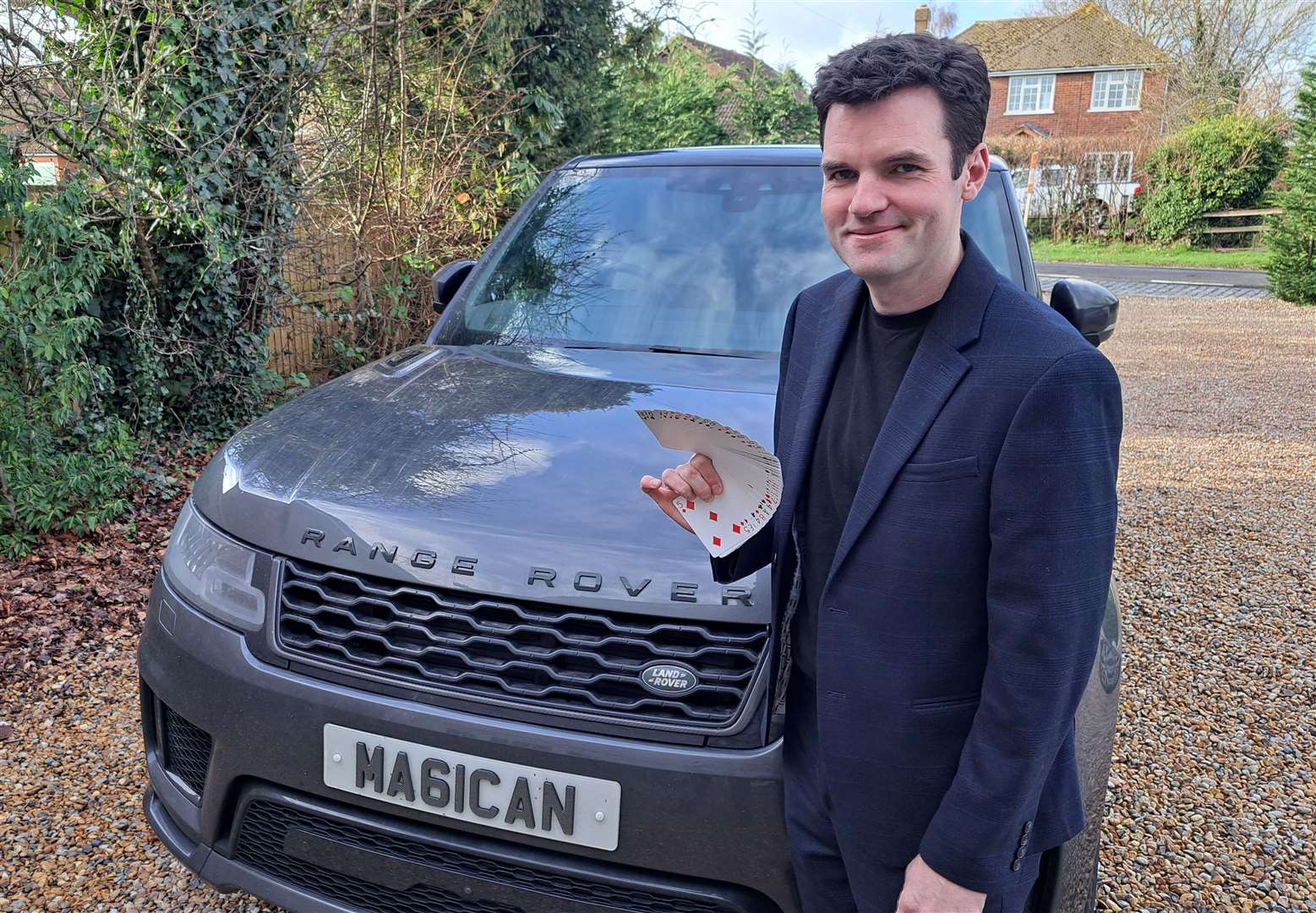 Ashford magician Chris Harding with his playing cards used for tricks and his car with a personalised number plate