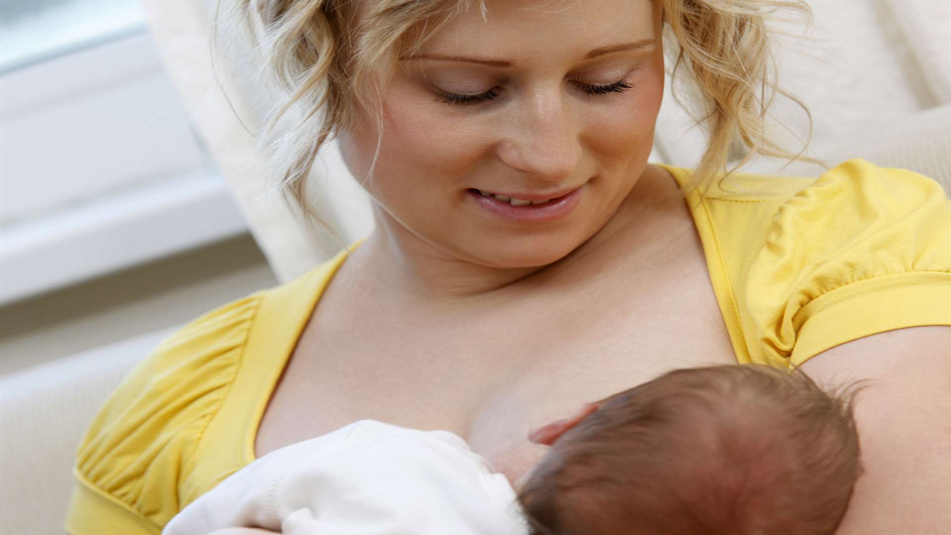 A young mother breast feeds her new born baby boy at home. Thinkstock image