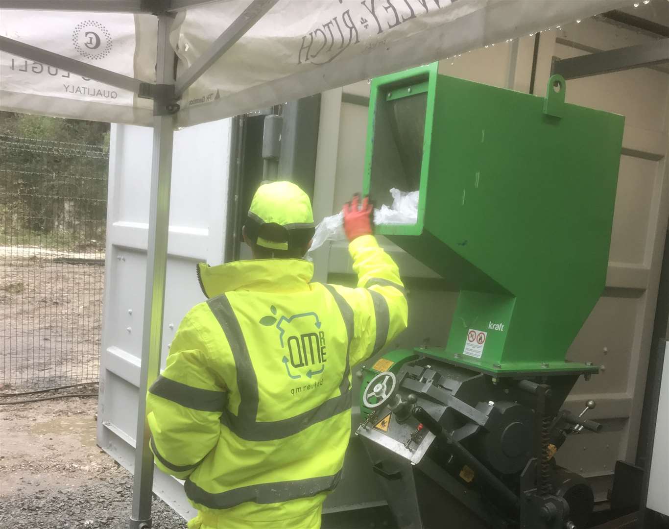 A QMRE operative filling the hopper with waste plastic