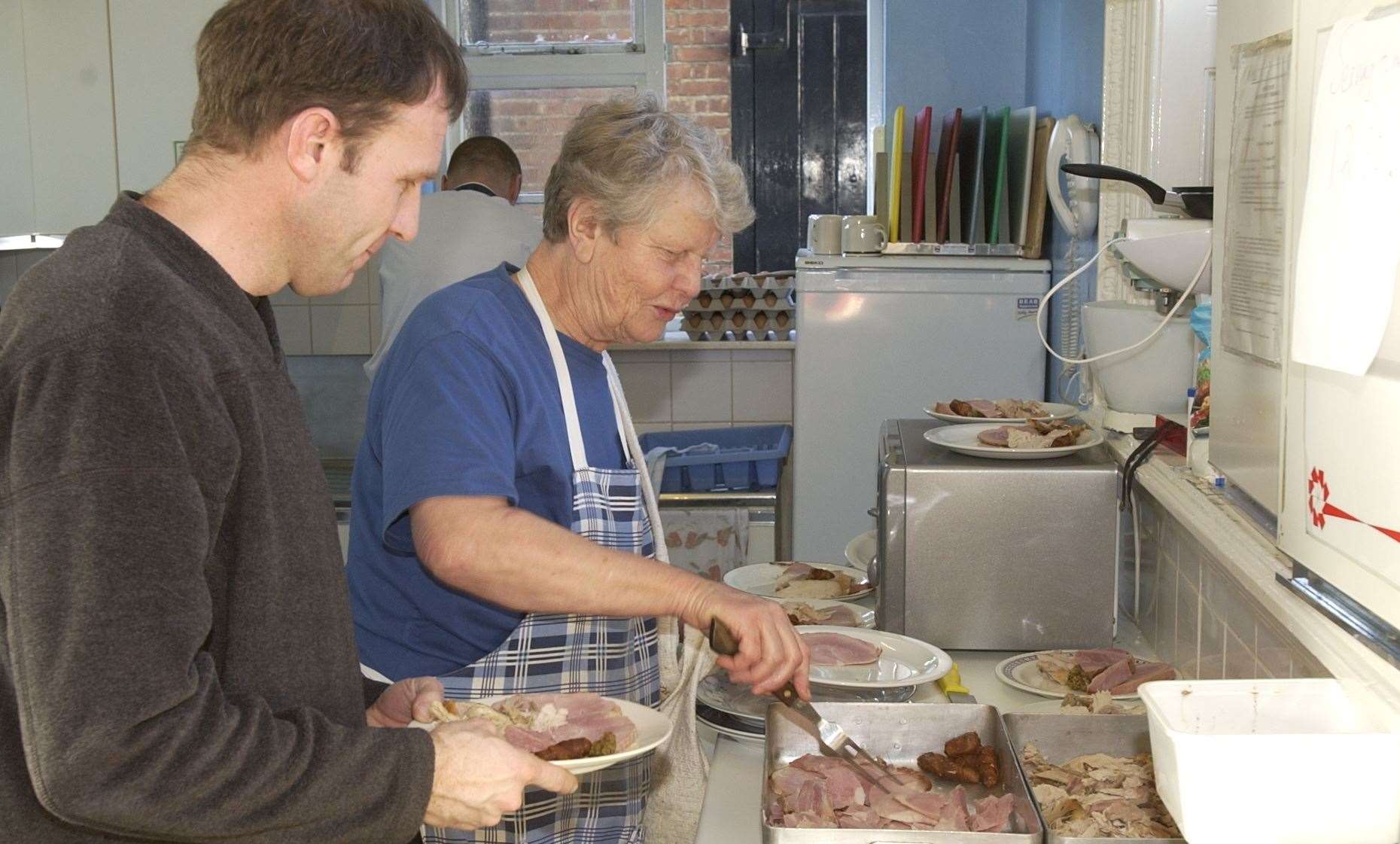 In 2001, a cook at Homeless Care, Mary Harvey, and helper Ian Edwards, prepare festive meals for the homeless