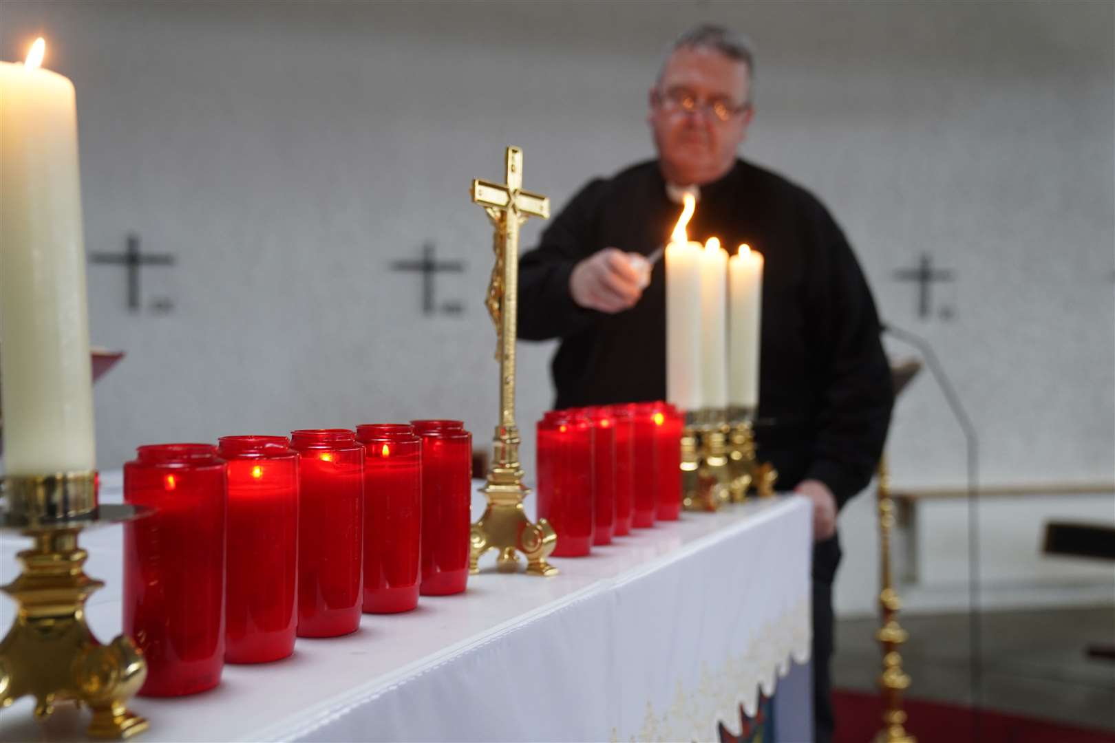 Father John Joe Duffy at ten candles that have been lit for the victims (Brian Lawless/PA)