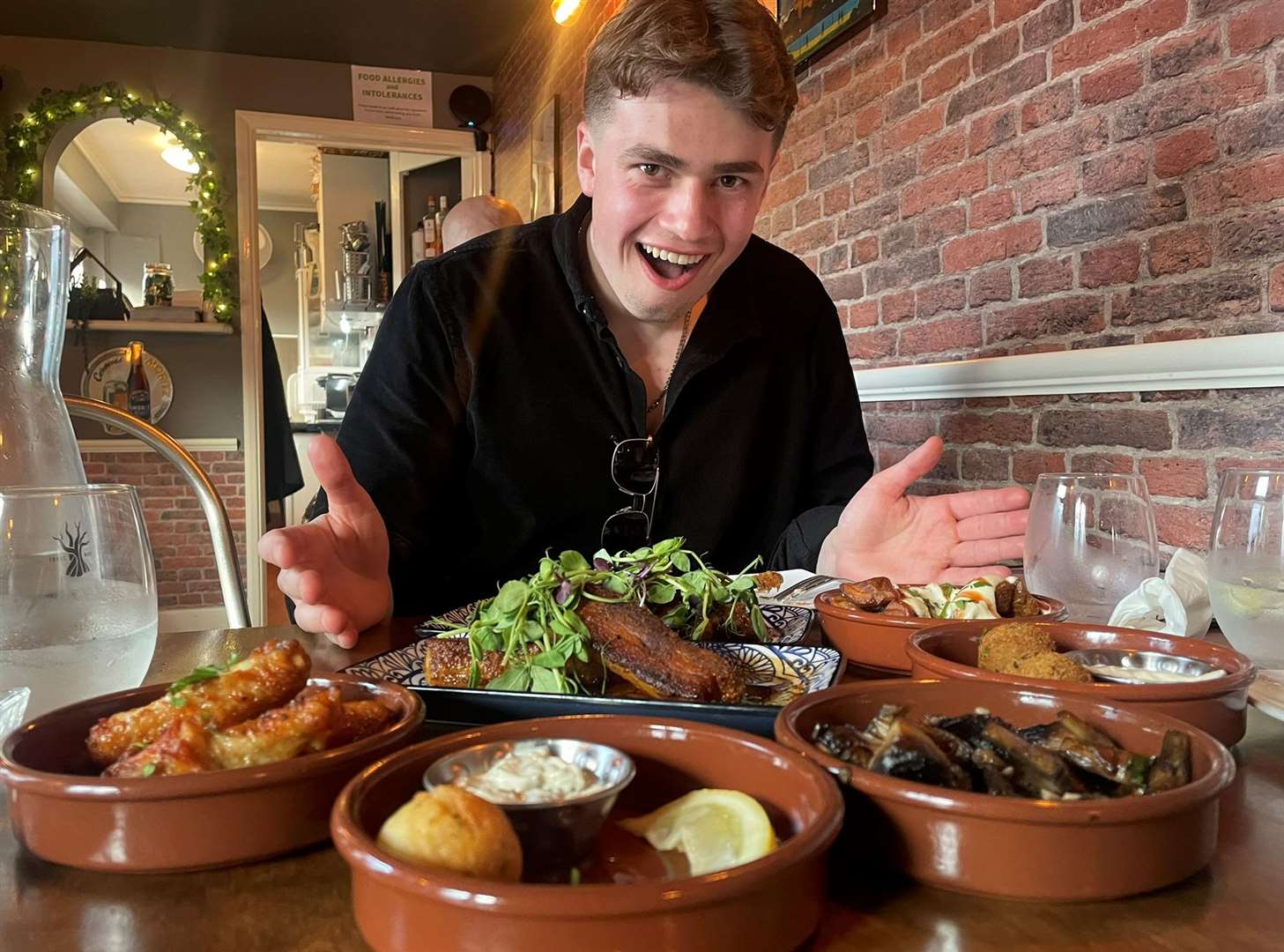 Reporter Joe Crossley surrounded by plates during a visit to West Street Tapas in Queenborough