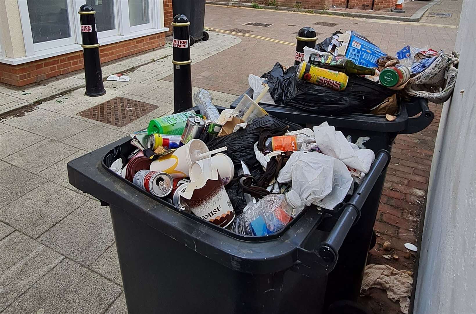 Rubbish bins overflowing surround the flats