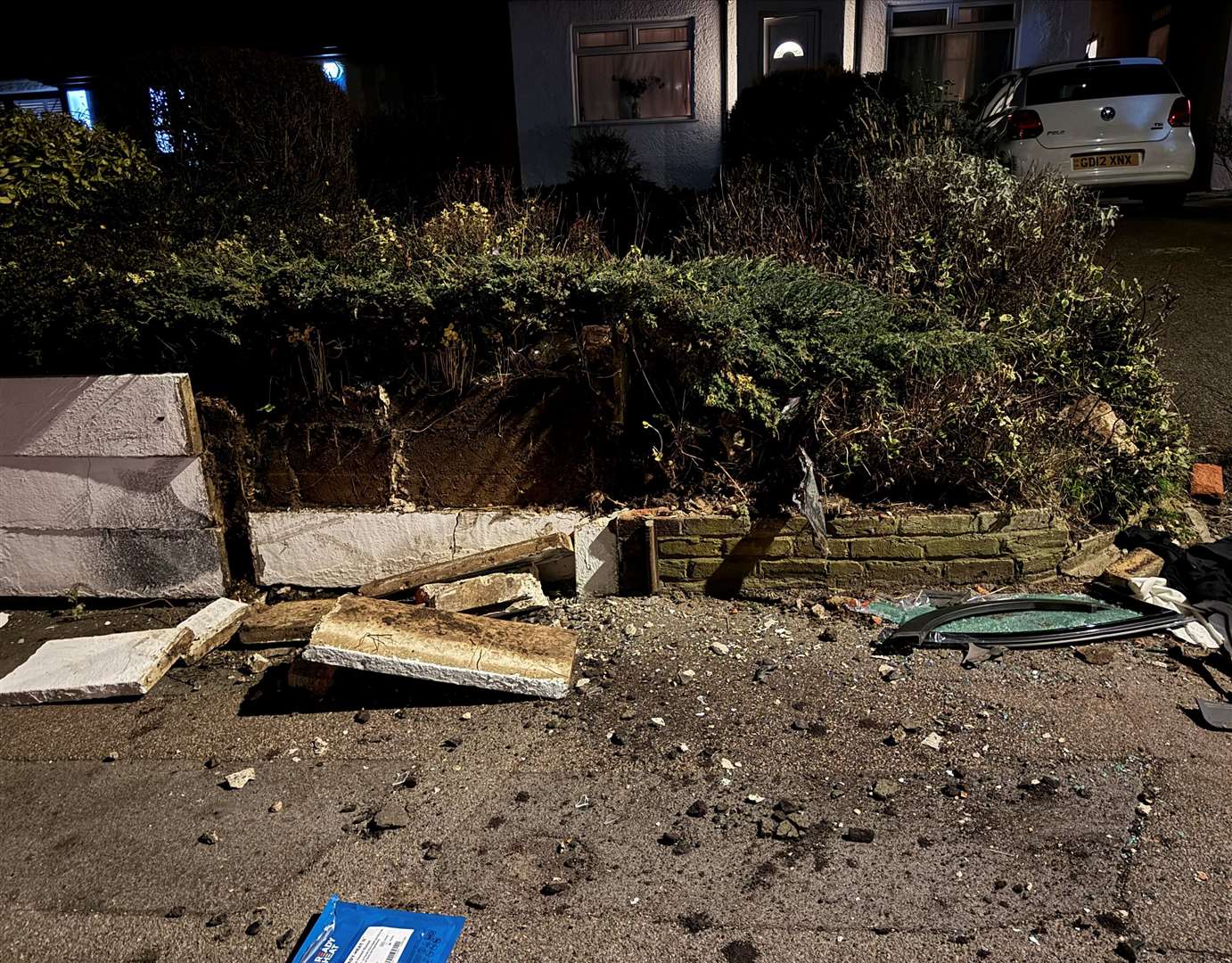 Debris and a smashed garden wall following the crash
