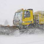 A snow plough makes its way through the winter weather