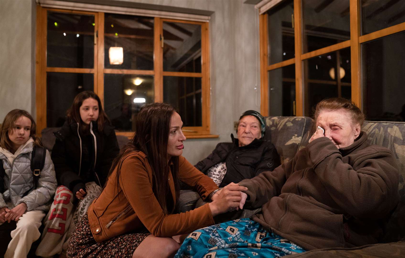 Ludmila Starkova, 90, (right) who fled Kharkiv in Ukraine, is comforted by Rend Platings, who connected the family with a businessman offering use of his house. (Joe Giddens/ PA)