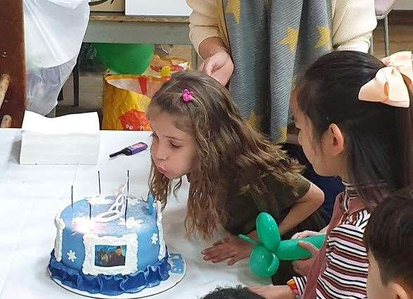 Emily blowing out the candles of her Frozen birthday cake
