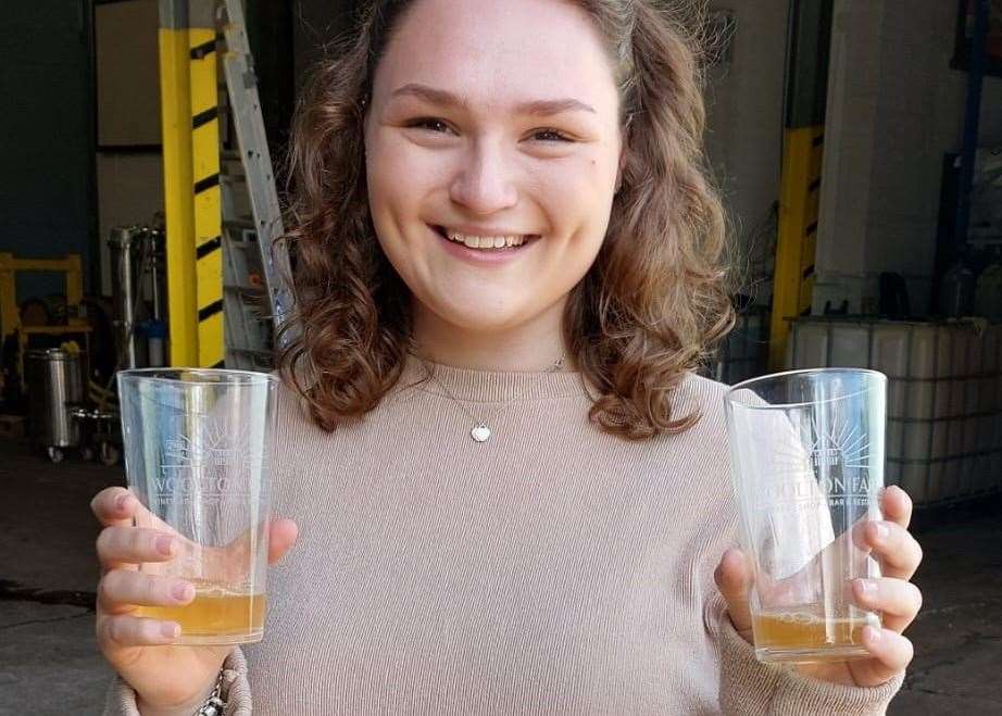 Megan Carr holding samples of Kentish Pip cider in its raw form
