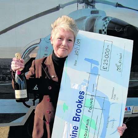 Larraine Brookes receives a cheque for £25,000 after winning the Kent Air Ambulance superdraw lottery