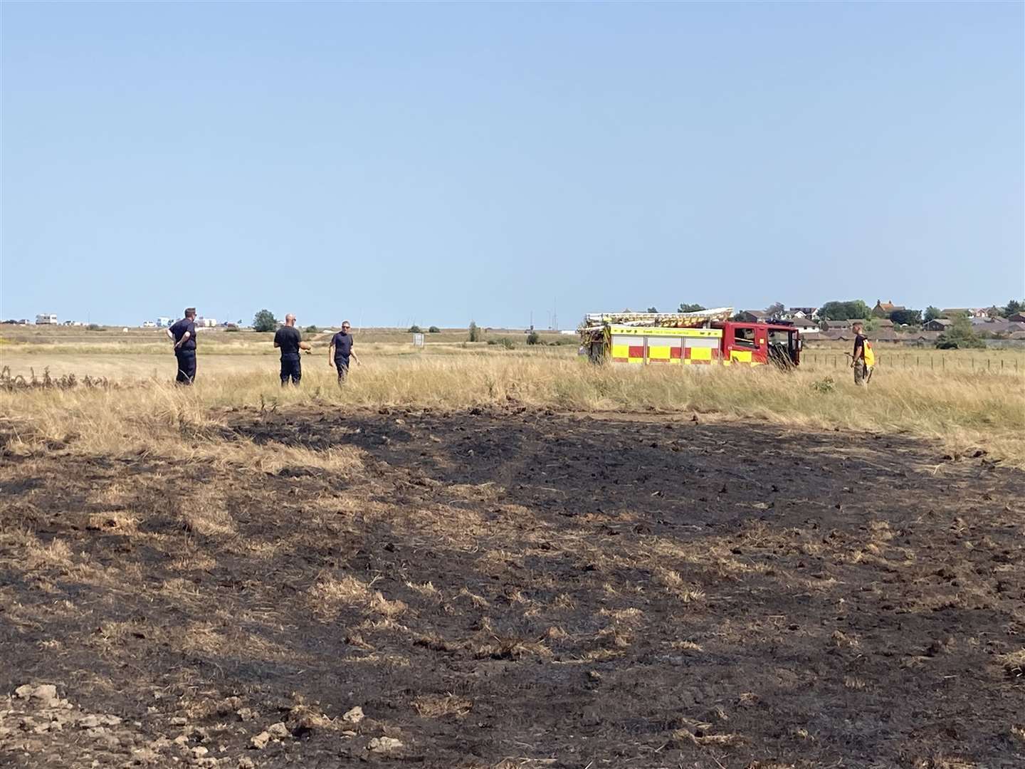 Fire crews dampening down the scorched earth at Barton's Point Coastal Park, Sheerness, on Monday after Saturday's blaze. Picture: John Nurden (58120030)