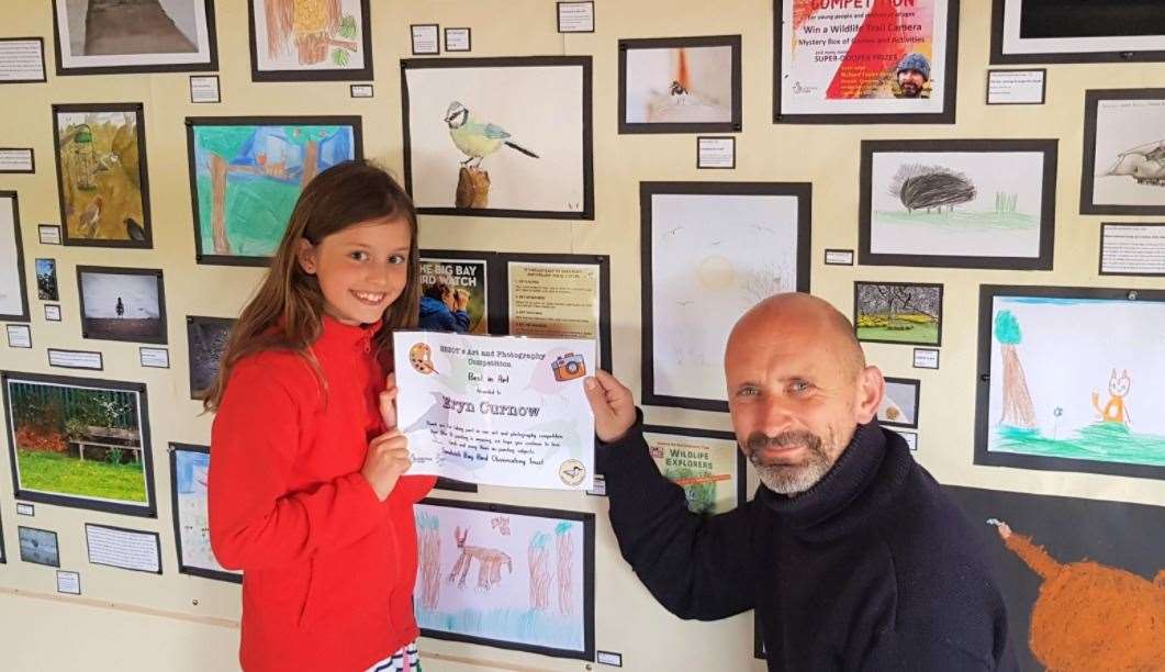 Eryn Curnow receives her certificate from Richard Taylor-Jones beside her picture of a blue tit
