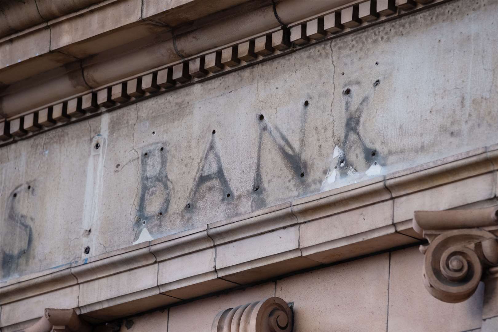 The remains of a sign over a former bank branch (Martin Keene/PA)